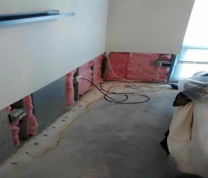 a room with the bottom portion of drywall missing with exposed insulatioon