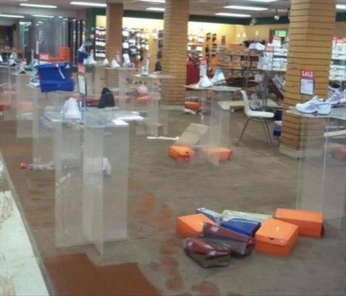 a shoe store with water on the floor and shoe boxes displaced